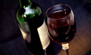 Бутылка красного вина с бокалом