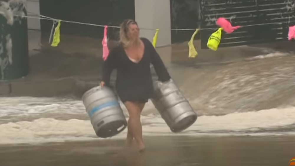 Женщина не испугалась урагана и бросилась в воду спасать пивные кеги и попала на видео