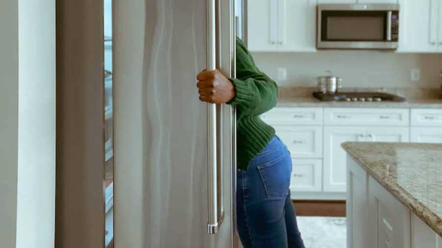 Женщина смотрит в холодильник